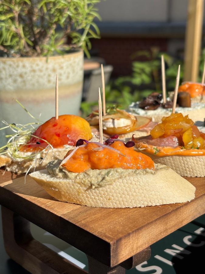 Pintxos mit Spießen auf einem Holzbrett im TXOKO