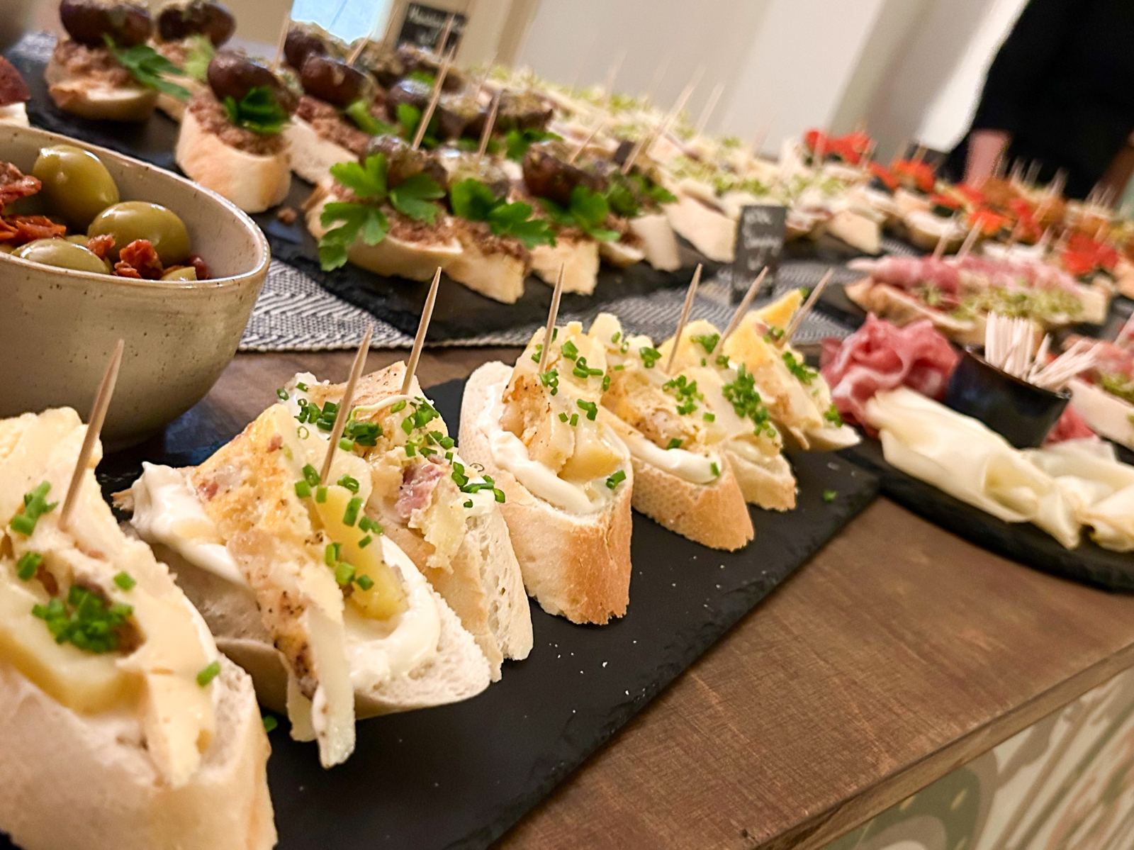 Lange Reihe verschiedener Pintxos auf Schieferplatten